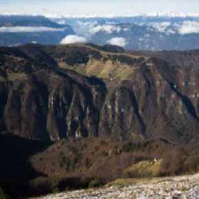 La sottostante Valle di Seren vista dai Solaroli, con le Dolomiti sull'orizzonte